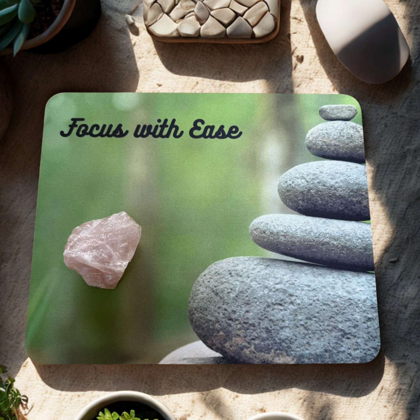 Affirmation mouse pad with stones and text 'Focus with Ease' green background with a rose quartz cluster