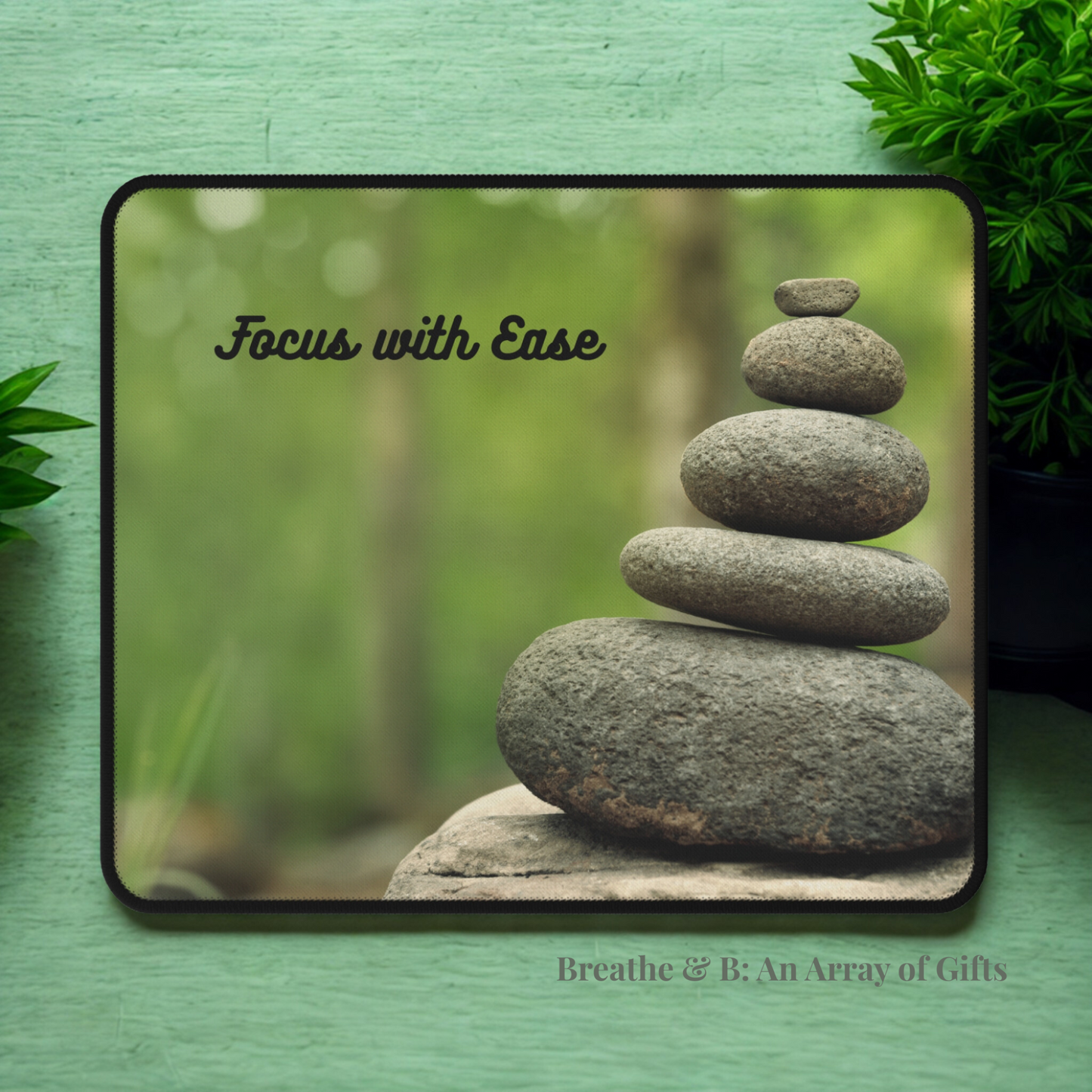 Balancing Stones with 'Focus with Ease' text on a mouse pad