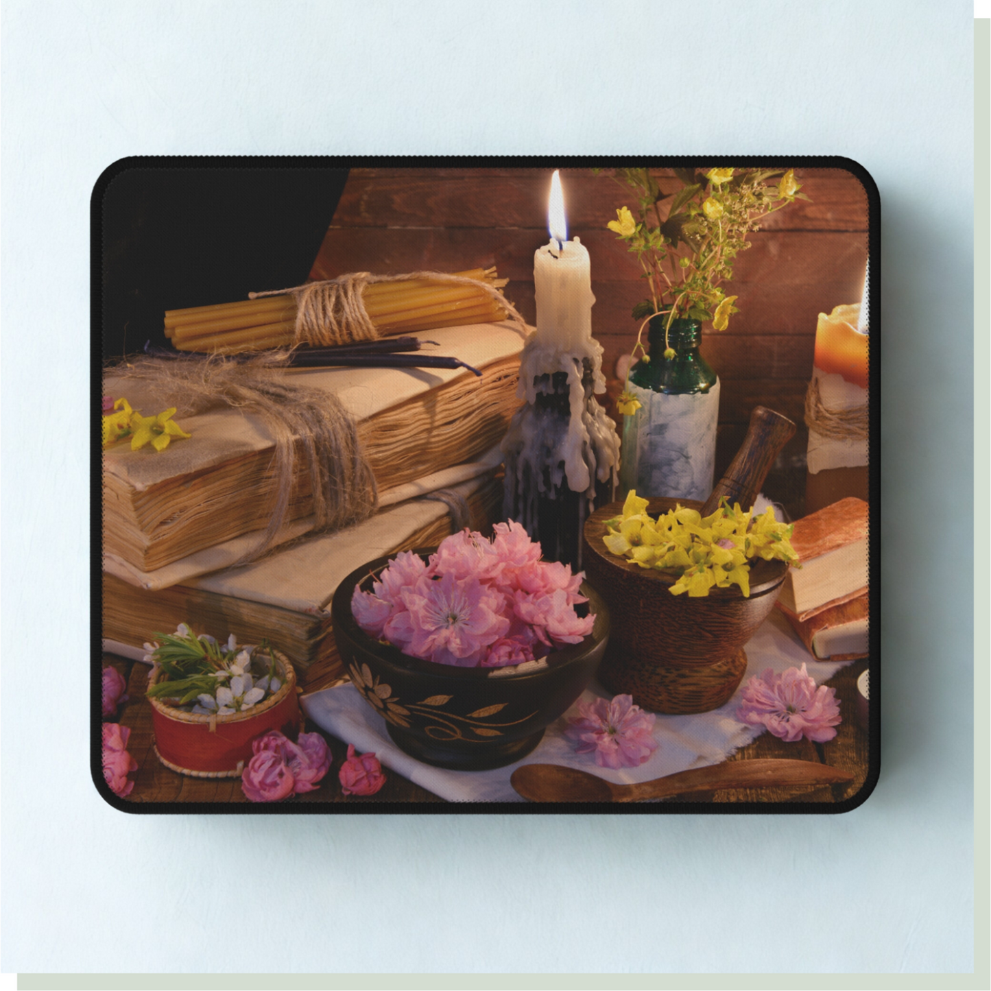 Mouse pad with a design of books, flowers, and a candle