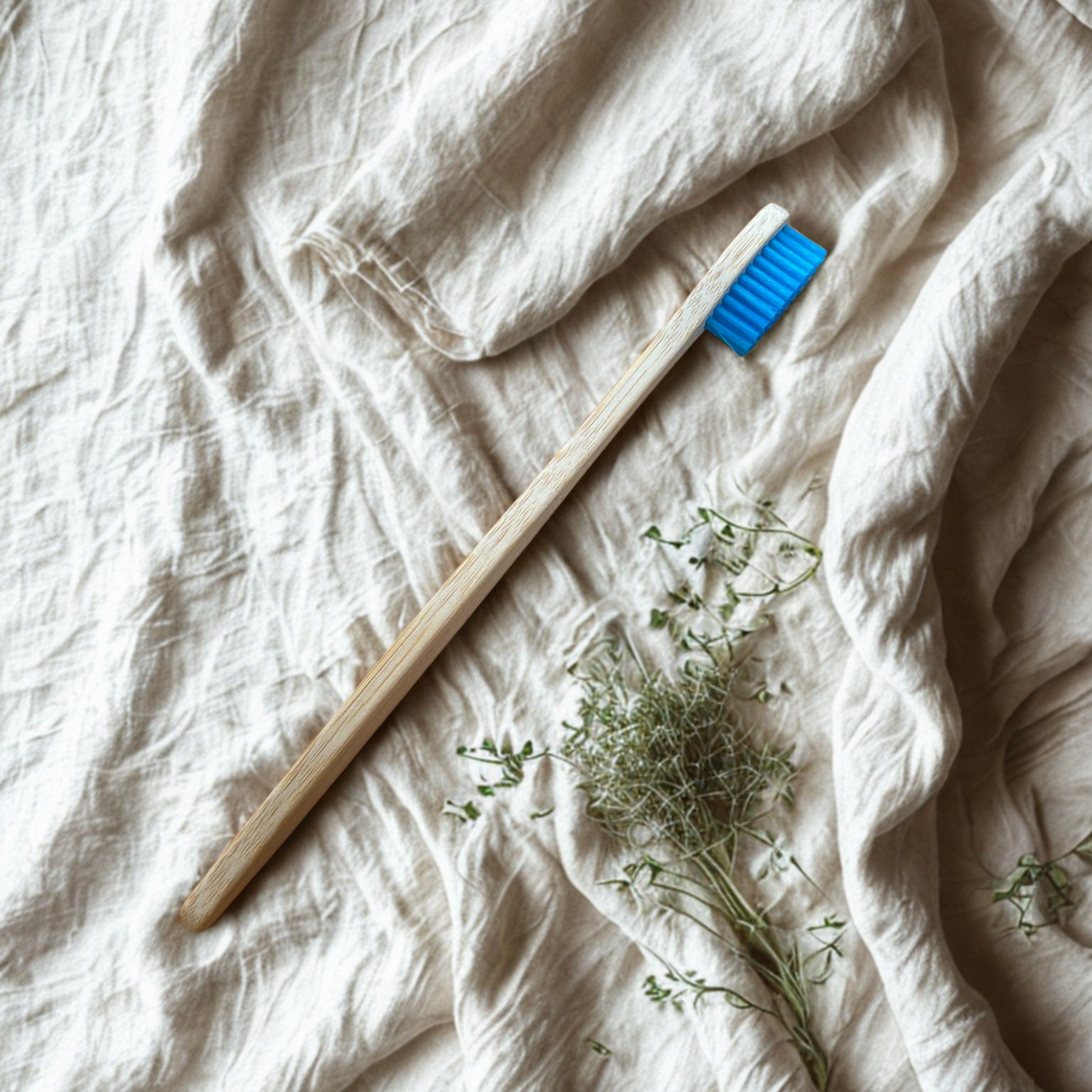 Adult bamboo toothbrush on a textured white fabric surface