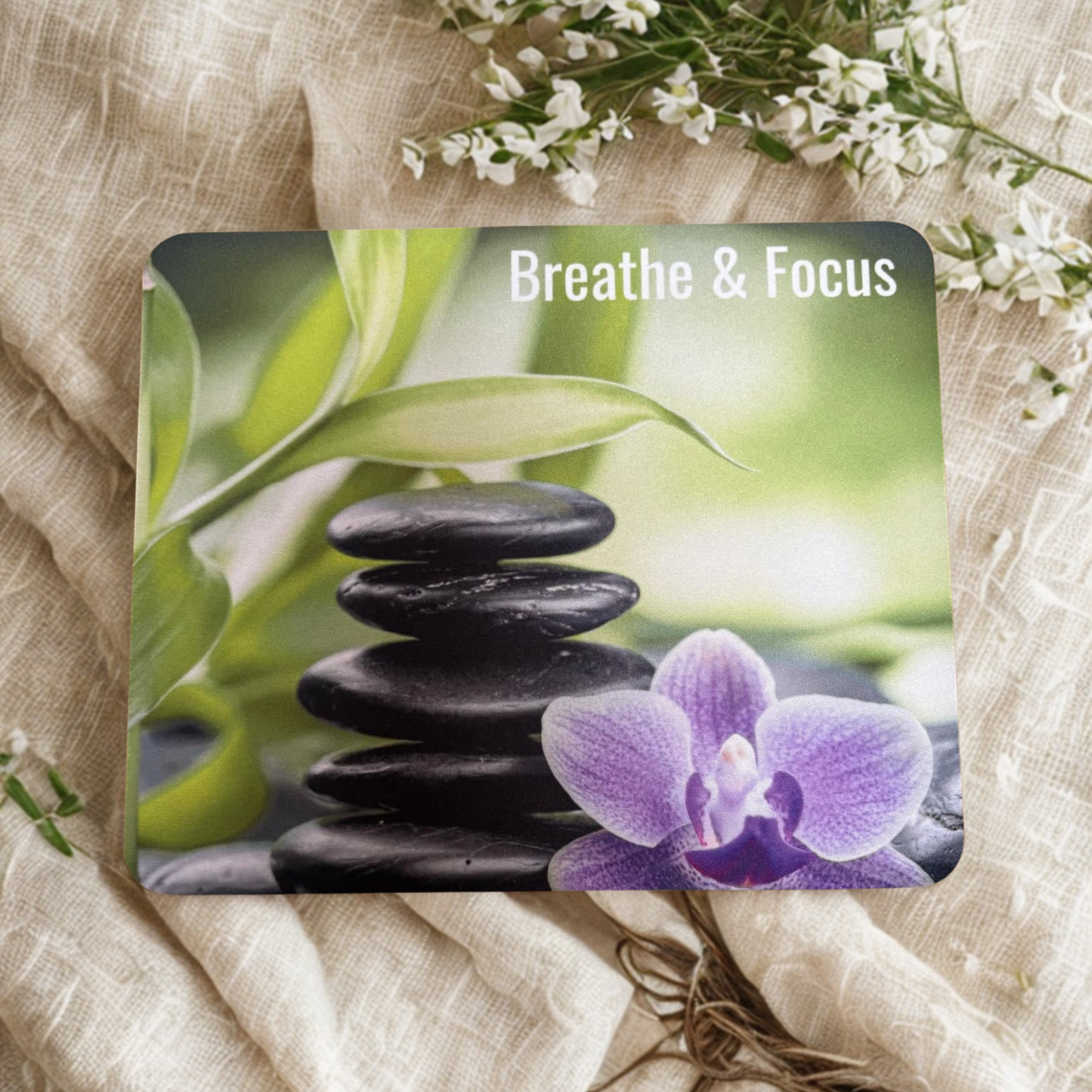 Affirmation Mouse Pad with stacked stones, purple orchid, and 'Breathe & Focus' text on a natural fabric background.