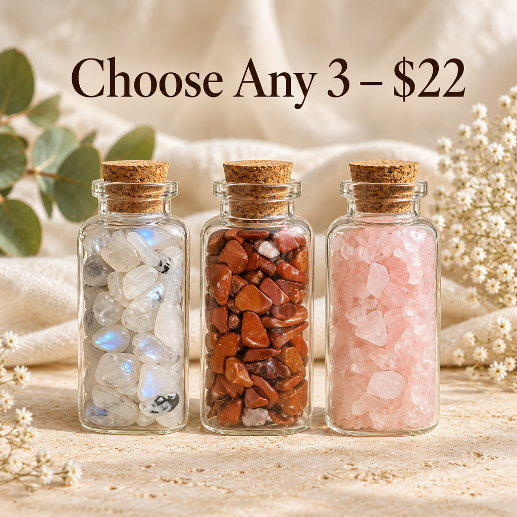 Three miniature glass bottles filled with assorted natural crystal chips and finished with cork stoppers. Image displays Choose Any 3 for $22, highlighting the mix-and-match crystal gift bundle from Breathe & B.