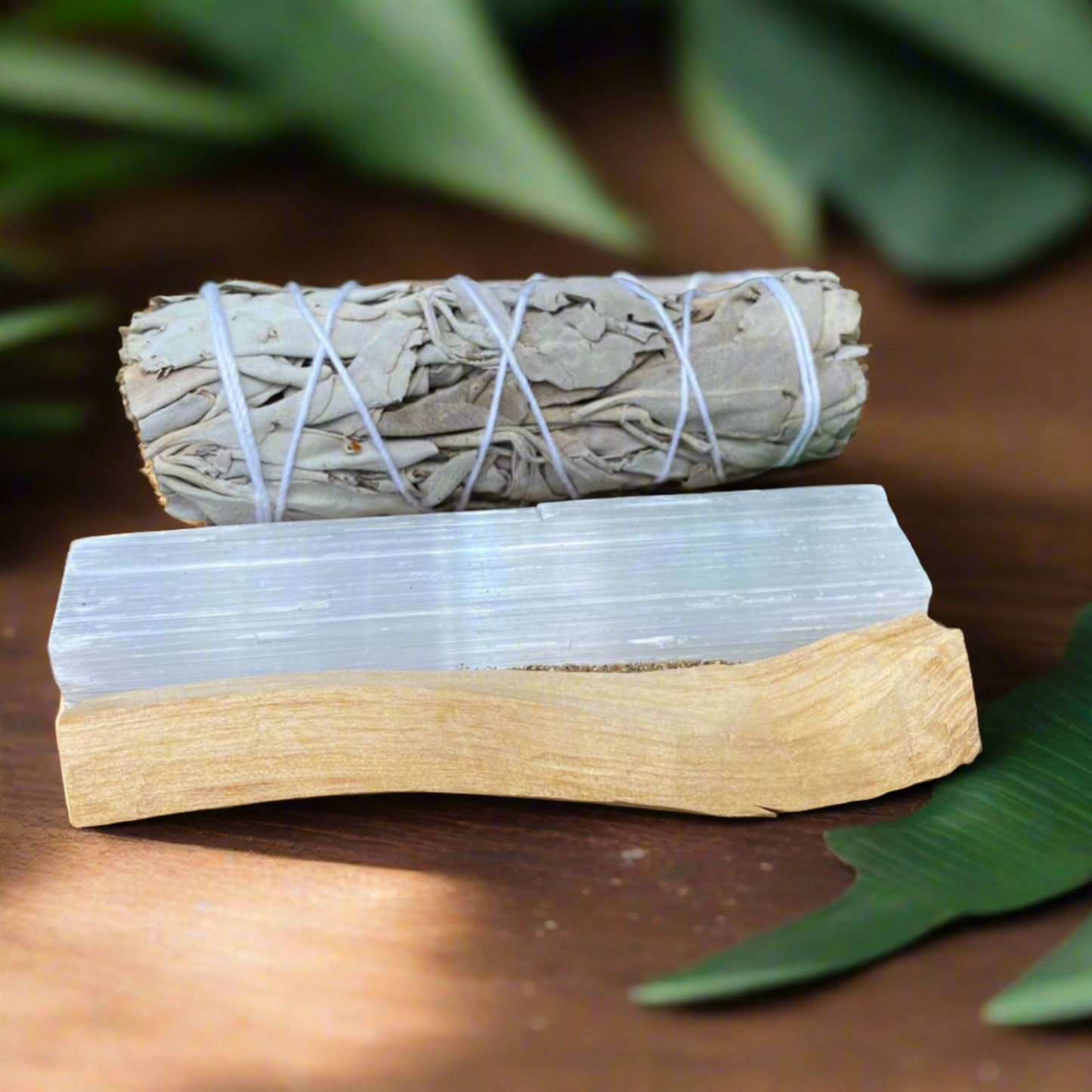 Close up of sage smudge stick, palo santo wood and selenite rod used in energy cleansing rituals