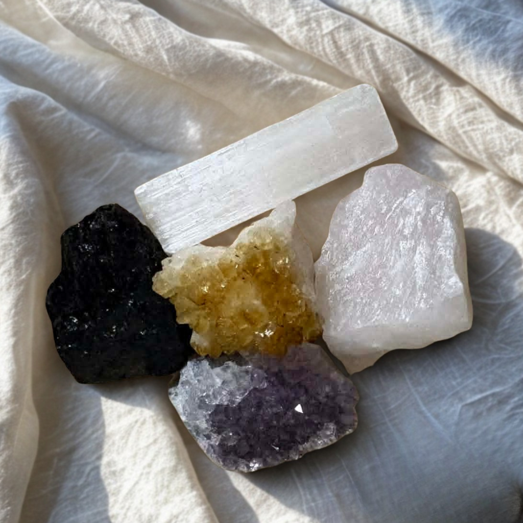 Crystal kit for calm and anxiety relief with amethyst, citrine, rose quartz, black tourmaline and selenite healing crystals flat lay on neutral background
