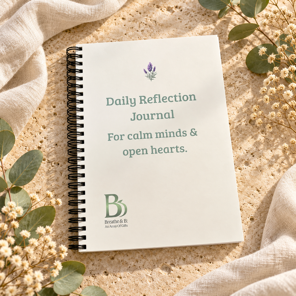 A spiral-bound Daily Reflection Journal with a white cover, styled on a sandy surface with linen fabric and small white flowers. The cover features a lavender sprig illustration, the title 'Daily Reflection Journal For calm minds & open hearts.