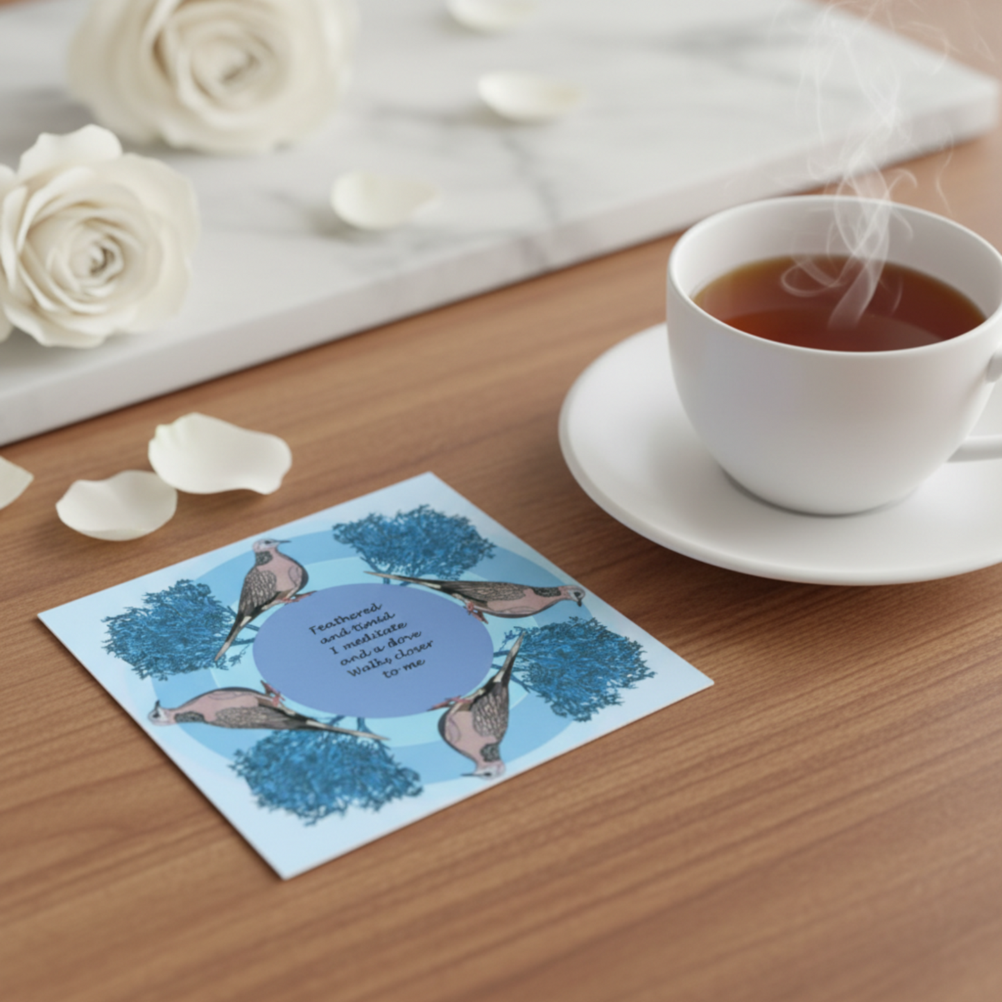 Bird greeting card placed on table with cup of tea and with soft natural styling flat lay
