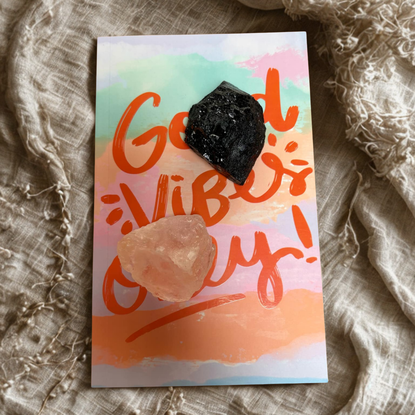 Notebook 'Good Vibes Only!' text and black tourmaline and salt chunk on a textured fabric background