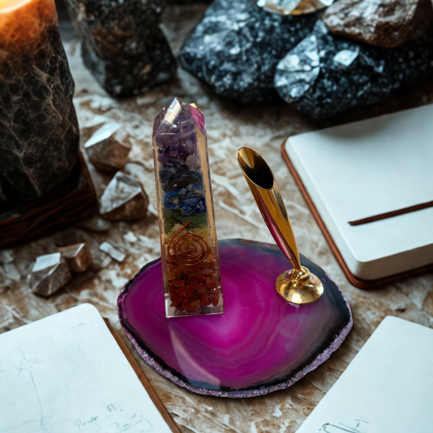 Orgonite Obelisk on a pink agate slice with pen holder, with crystals and books in the background