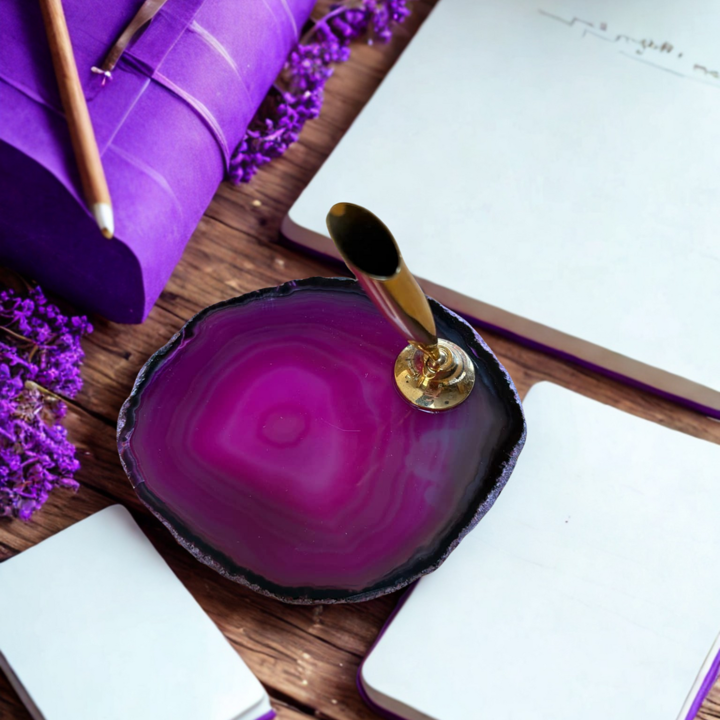 Pink agate slice with pen holder, with notebooks and flowers.