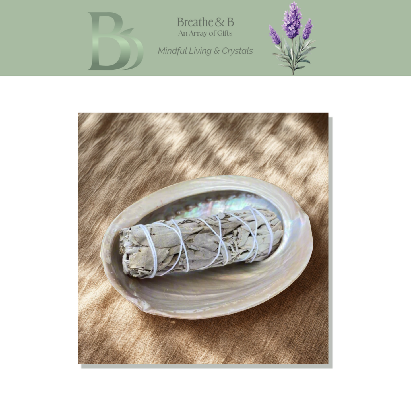Sage bundle in a abalone shell on a wooden surface with 'Breathe & B' branding.