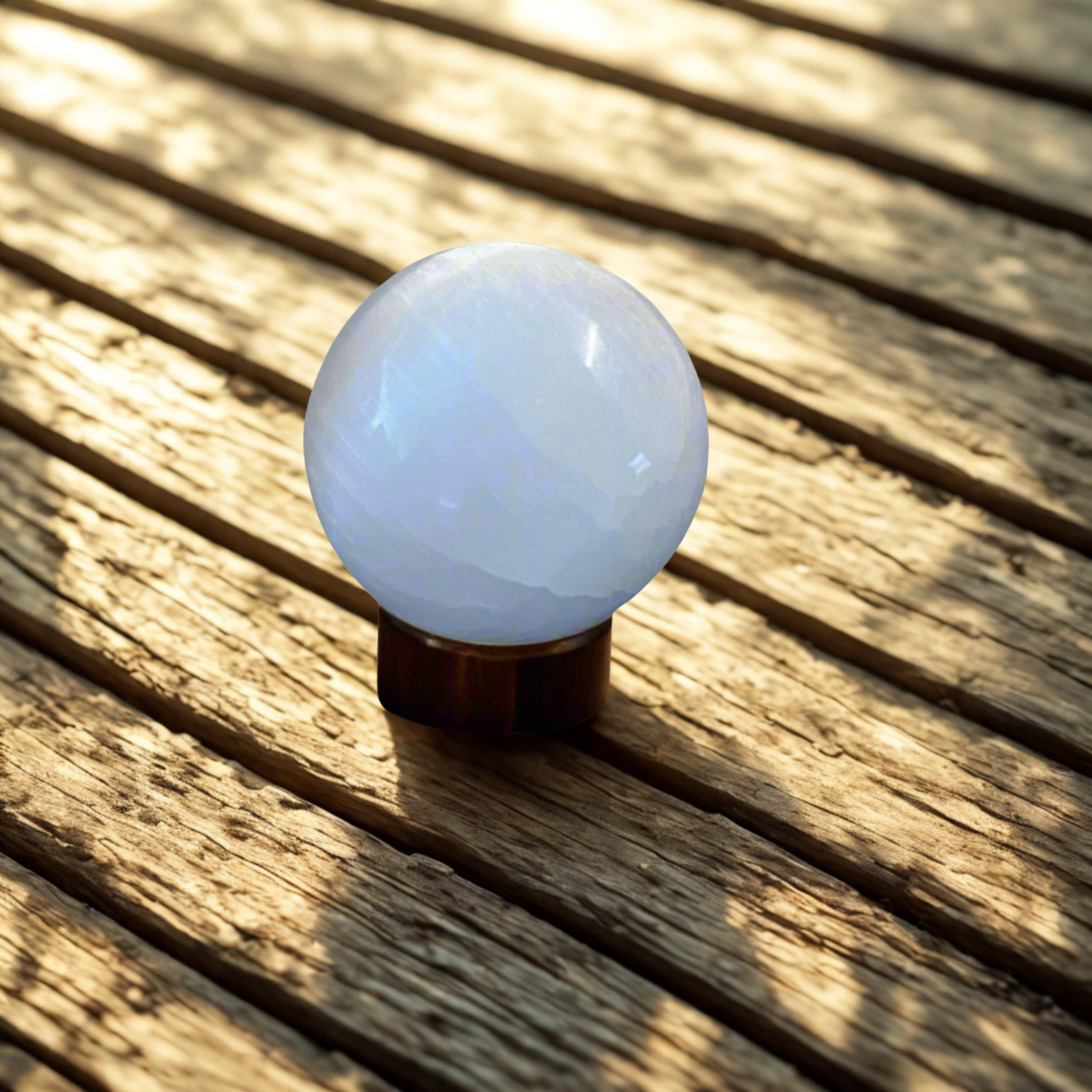 White selenite spherel object on a wooden surface