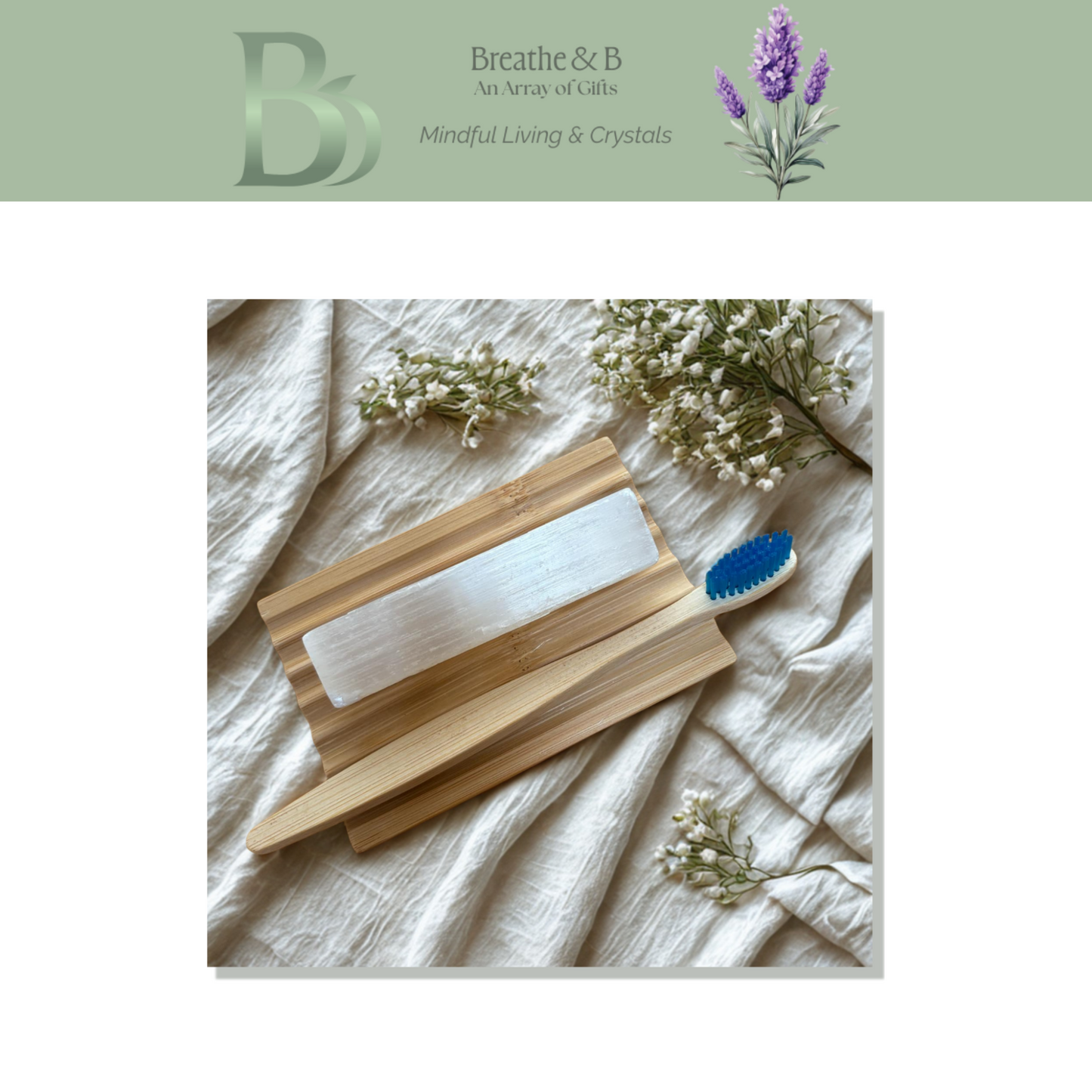 Wooden soap dish, bamboo toothbrush with selenite rod on a textured surface with flowers, featuring the brand 'Breathe & B'.