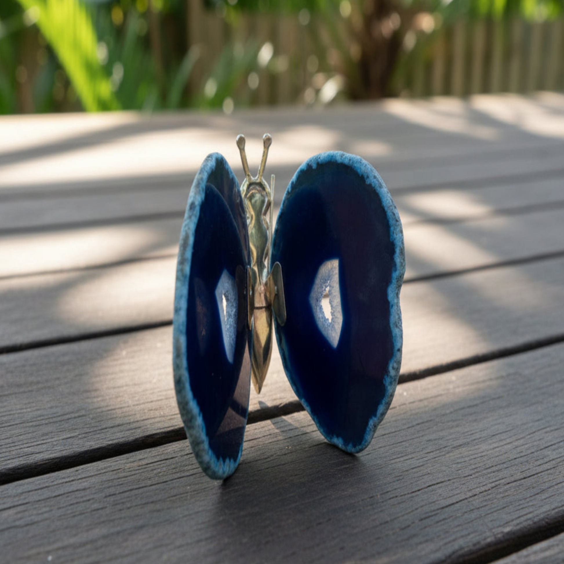 Blue agate butterfly on a wooden surface with a blurred natural background