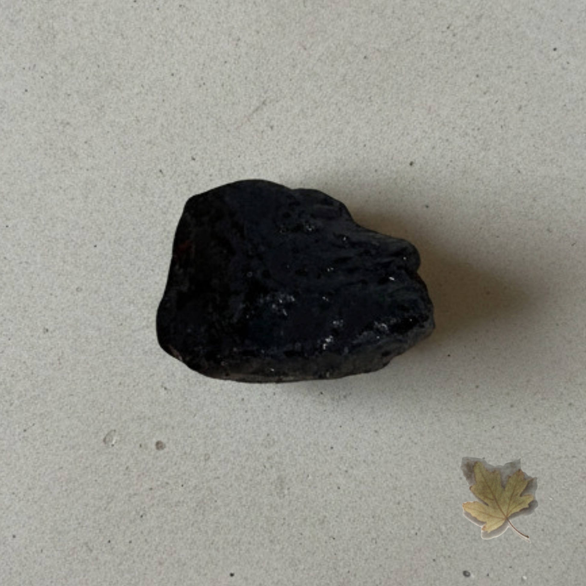 Natural black tourmaline stone close-up showing raw texture, used for grounding, protection and emotional balance